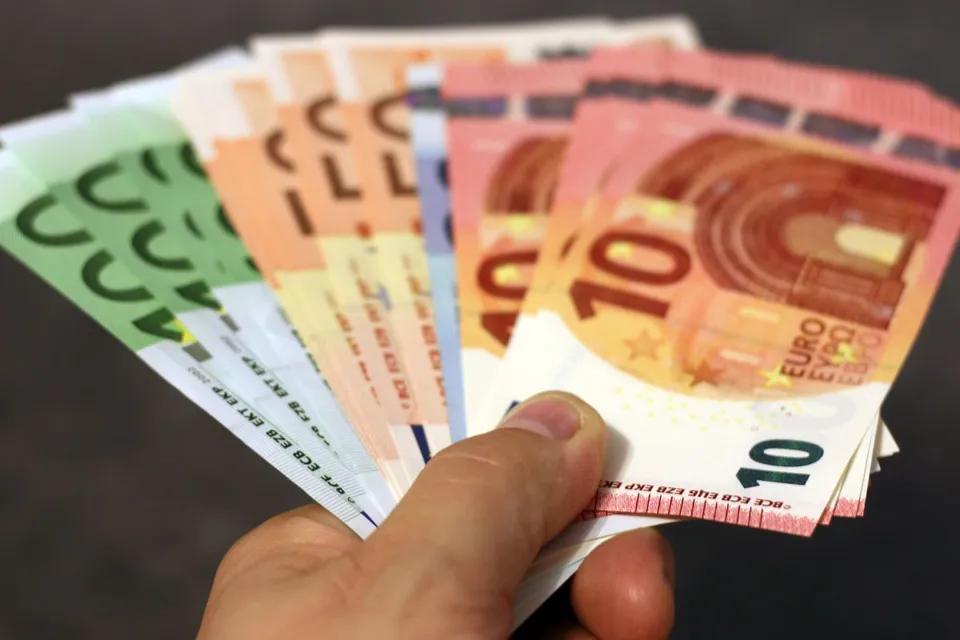 Una mano sujeta en abanico varios billetes de euro de 10, 20, 50 y 100