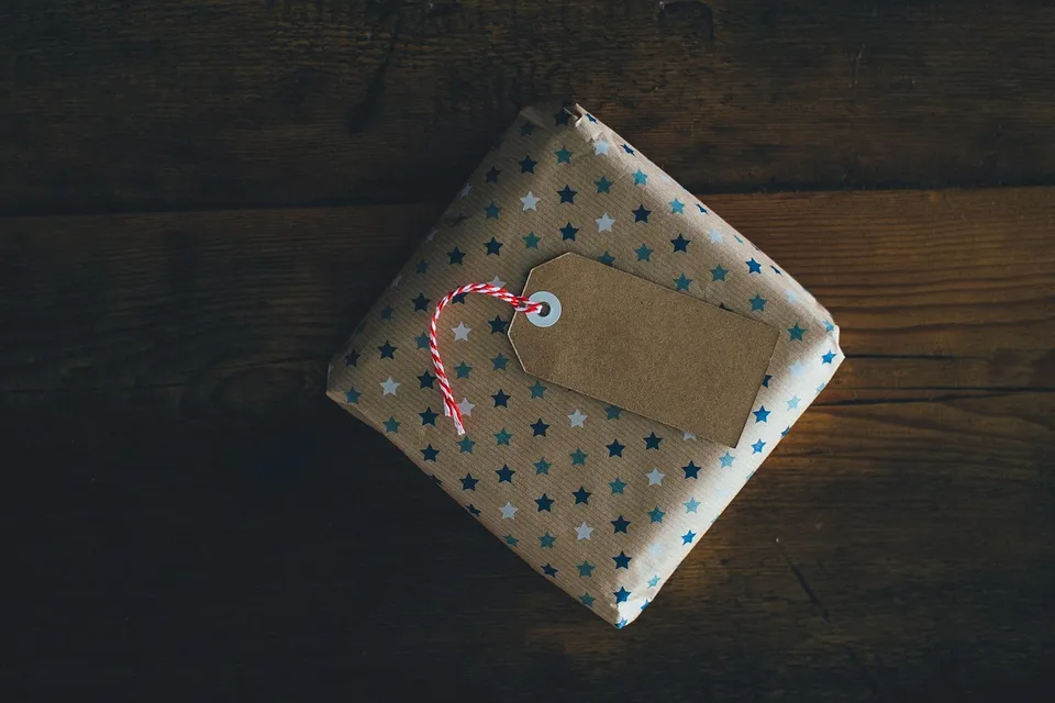 Un regalo pequeño envuelto en papel de estrellas con una etiqueta de cartón en blanco